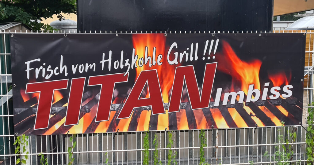 Bedrucktes Bauzaunbanner mit Firmenlogo, gefertigt von c&w - das Werbezentrum in Geretsried, als Beispiel für langlebige Außenwerbung.