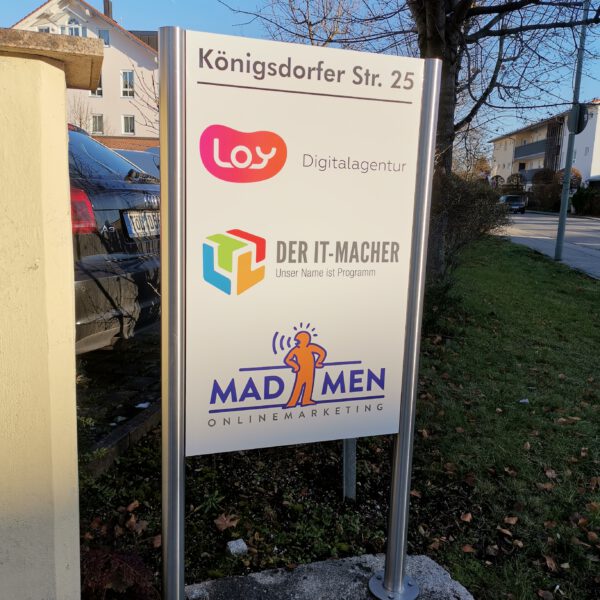 Modernes Firmenschild aus gebürstetem Edelstahl an einer Firmenfassade, gefertigt von c&w - das Werbezentrum in Geretsried. Das Schild zeigt ein präzise gelasertes Logo und unterstreicht den professionellen und hochwertigen Firmenauftritt.