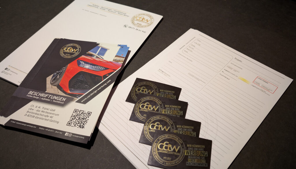 Professionell gestaltete Geschäftsdrucke von c&w - das Werbezentrum in Geretsried: Eine Auswahl von Visitenkarten, Flyern und Briefpapier, die Kompetenz und Qualität ausstrahlen.